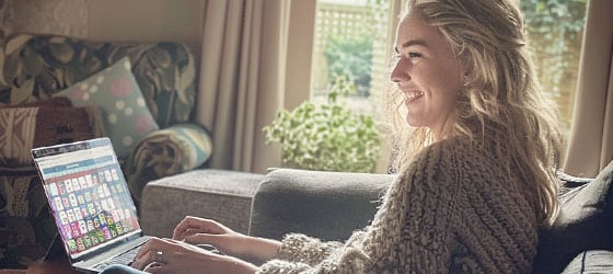 A woman is online gaming on her laptop