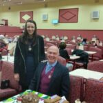 The deputy mayor sells cakes for charity at the club.